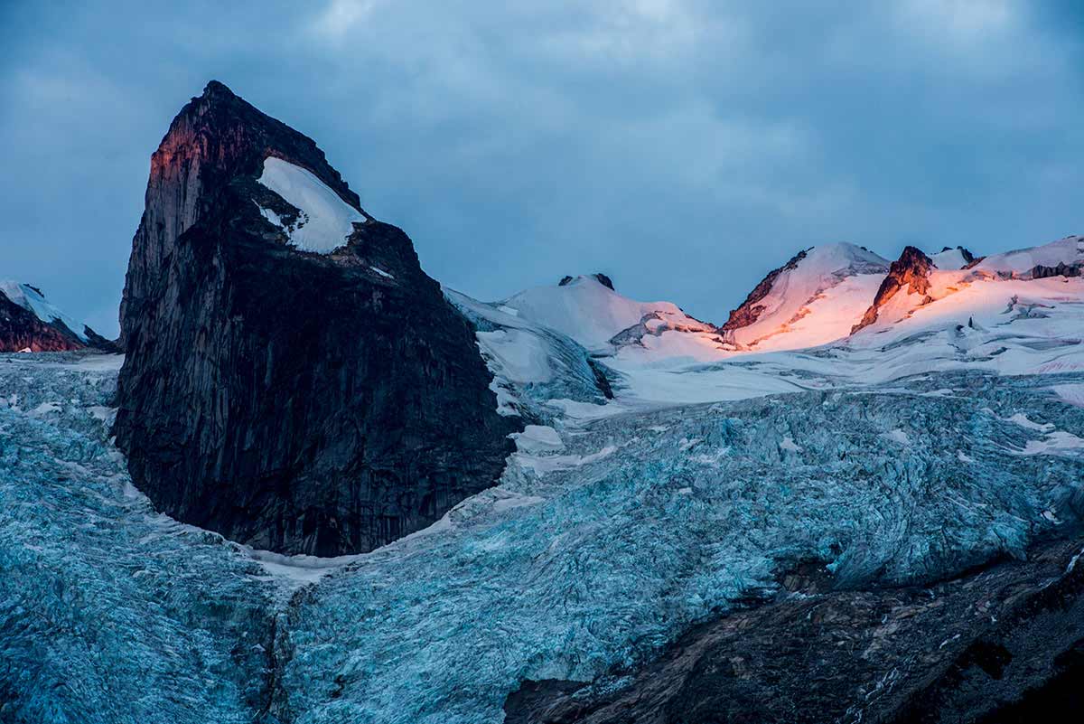 First light hitting the Pigeon Feathers. Houndstooth Peak is the prominent peak coming out of Bugaboo Glacier. Bugaboo Group in the Purcell Mountain Range. British Columbia, Canada. © Neil Ever Osborne