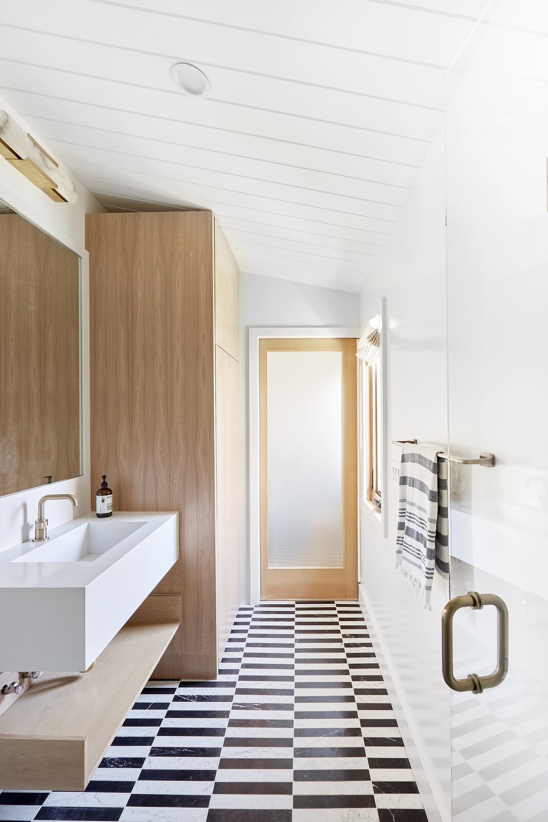 the-bathroom-features-custom-black-and-white-carrara-marble-flooring.jpg