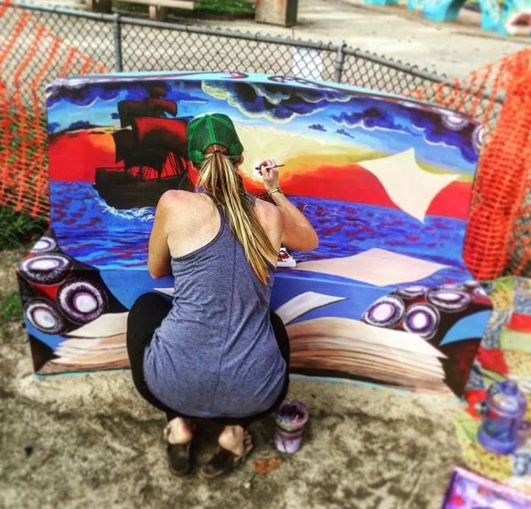 This project was commissioned by Bookshop Santa Cruz for their Artful Reading Benches collaboration with the city of Santa Cruz. Three artists were selected to design murals to be installed on concrete benches throughout the city of Santa Cruz for the purpose of inspiring children to read. Terra Dawson was one of the lucky artists. This picture shows her placing the finishing touches on the bench she designed. Acrylic on concrete. 