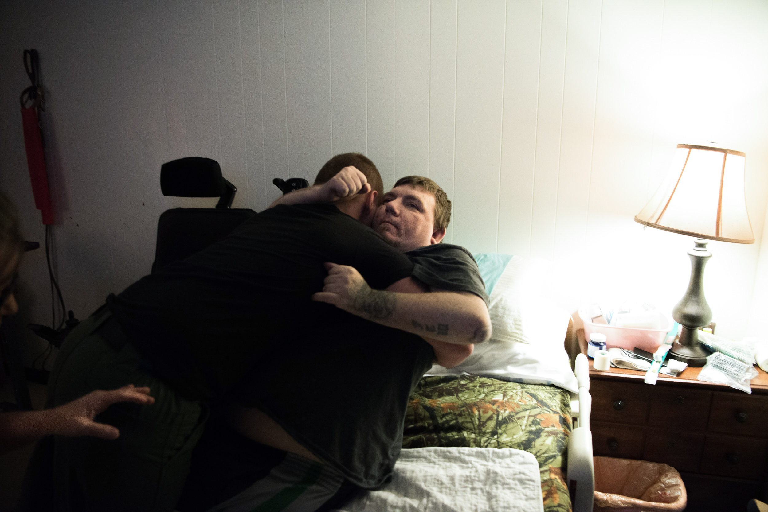  Adam’s cousin lifts him into bed after his sister forgot to stop by and help Chery move him. Chery is unable to make the transfer herself and usually relies on Adam’s aid or other family members. &nbsp; 
