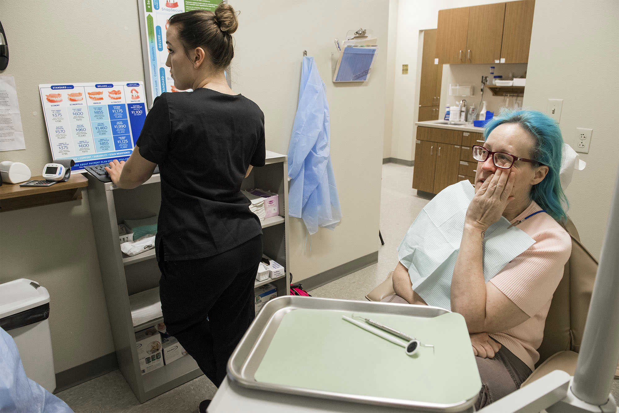  Dental Assistant Sam Mattix, left, shows Eyssen the results of her dental exam which Eyssen said confirmed the damage to her teeth is as bad as she thought, and prohibitively expensive to fix. 