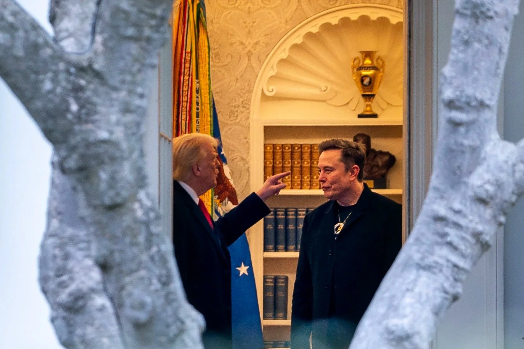  U.S. President Donald Trump points toward Tesla CEO Elon Musk during a conversation in the Oval Office at the White House, in Washington D.C. U.S., March 14, 2025. 