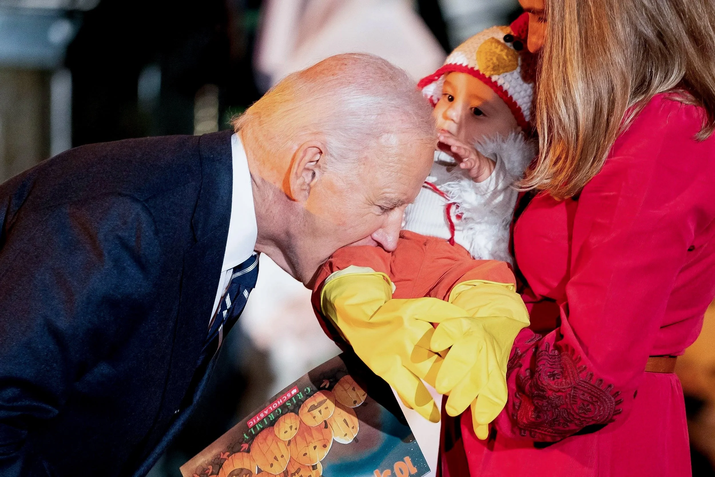  U.S. President Joe Biden playfully bites a baby during a trick-or-treaters celebration for Halloween at the White House in Washington, U.S., October 30, 2024. 