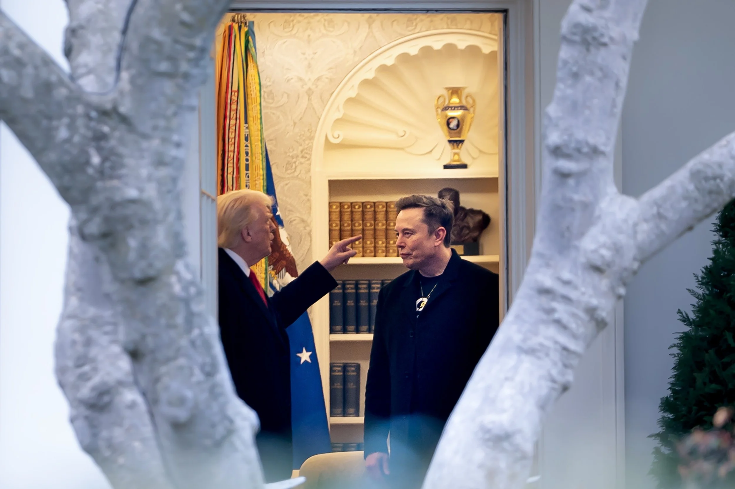  U.S. President Donald Trump points toward Tesla CEO Elon Musk during a conversation in the Oval Office at the White House, in Washington D.C. U.S., March 14, 2025. 