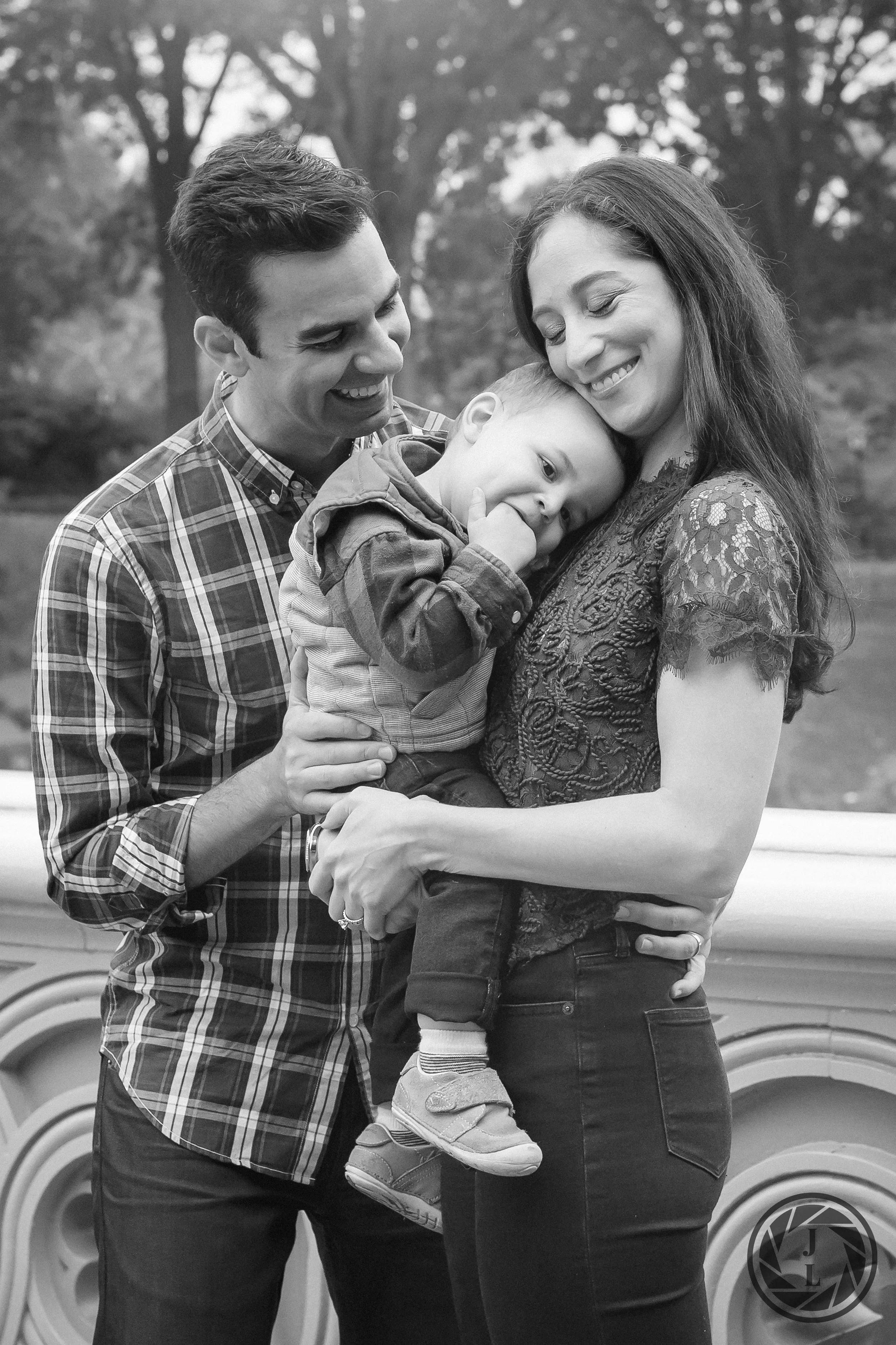 A family of three hugging and smiling