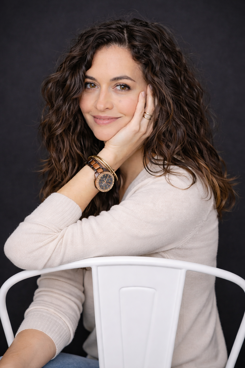 Headshot Photography - A woman poses for a headshot against a dark backdrop.