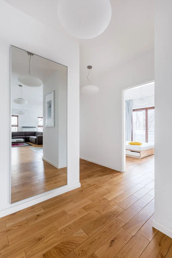 A framed 1/4" mirror wall mounted in an entryway, increasing the perception of space in the hallway.