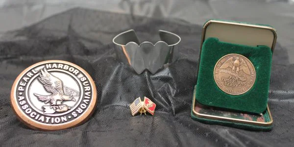 Sam Richiusa's medals, pin, and the Two Hearts Beating as One bracelet. 
