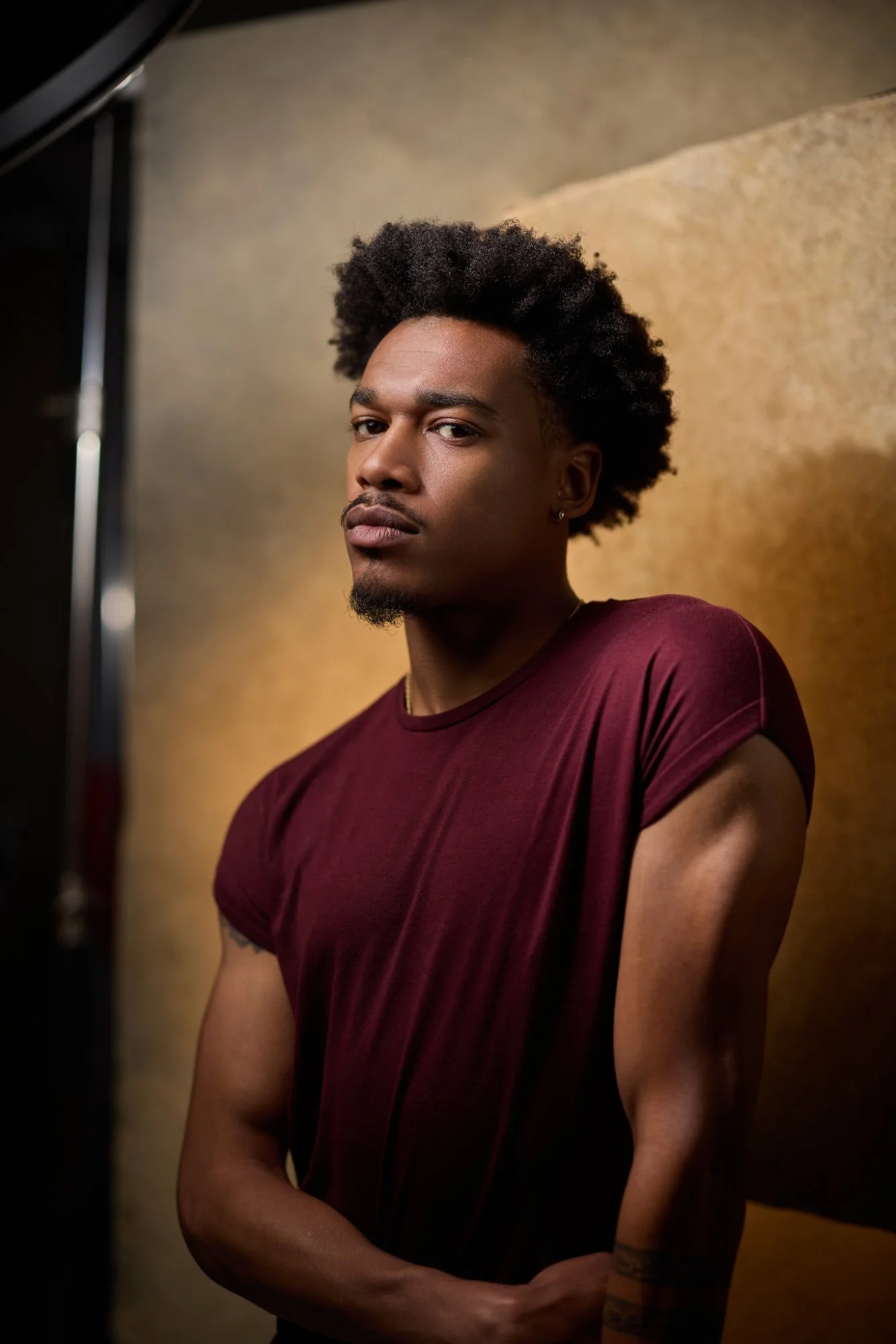 Actor headshot 2026 - male actor in maroon t-shirt on dark background