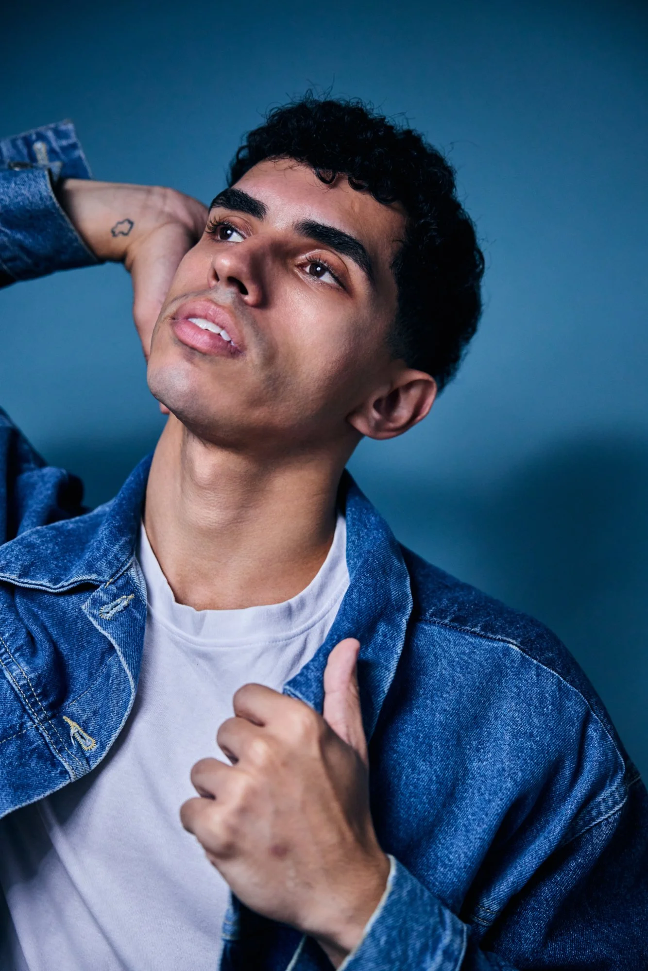 Actor headshot example - male actor in denim jacket on blue background