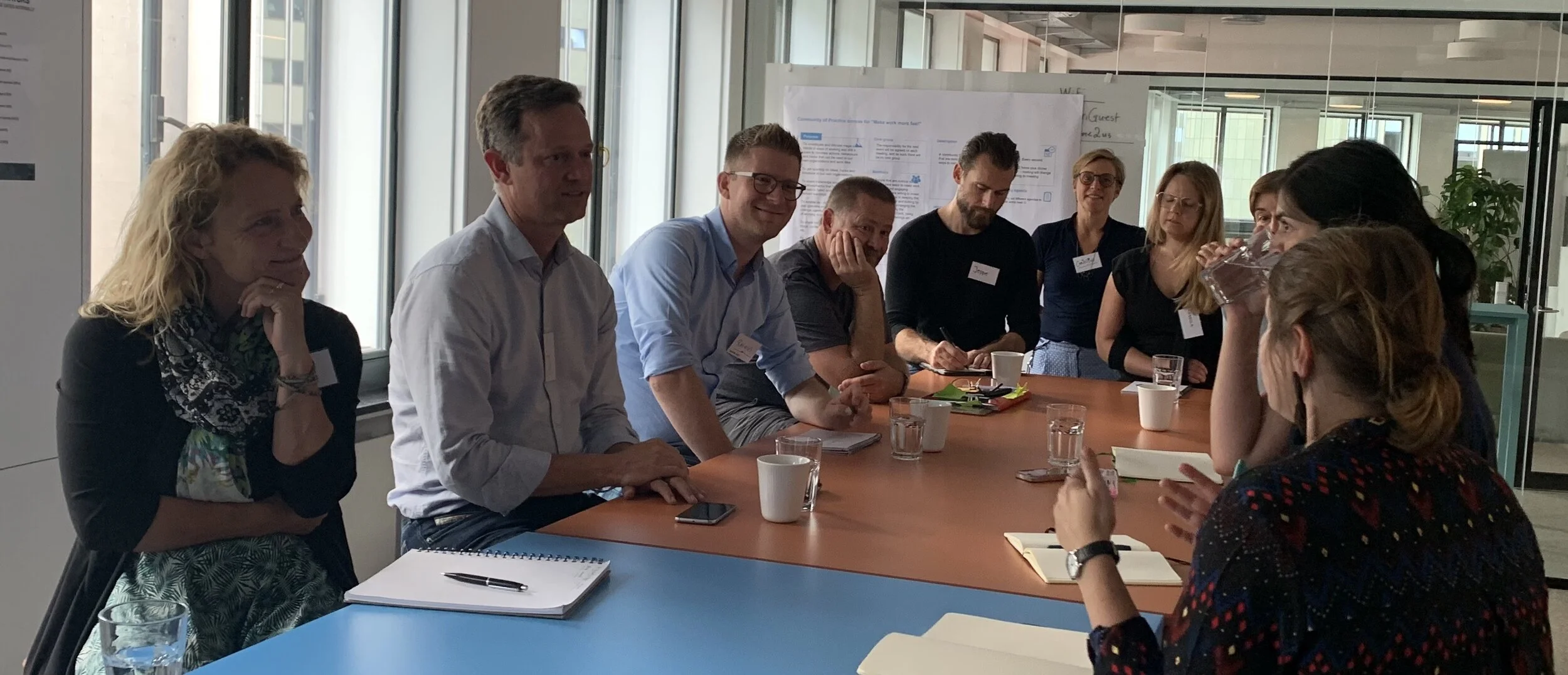 Participants gather at a table to discuss happiness at work.