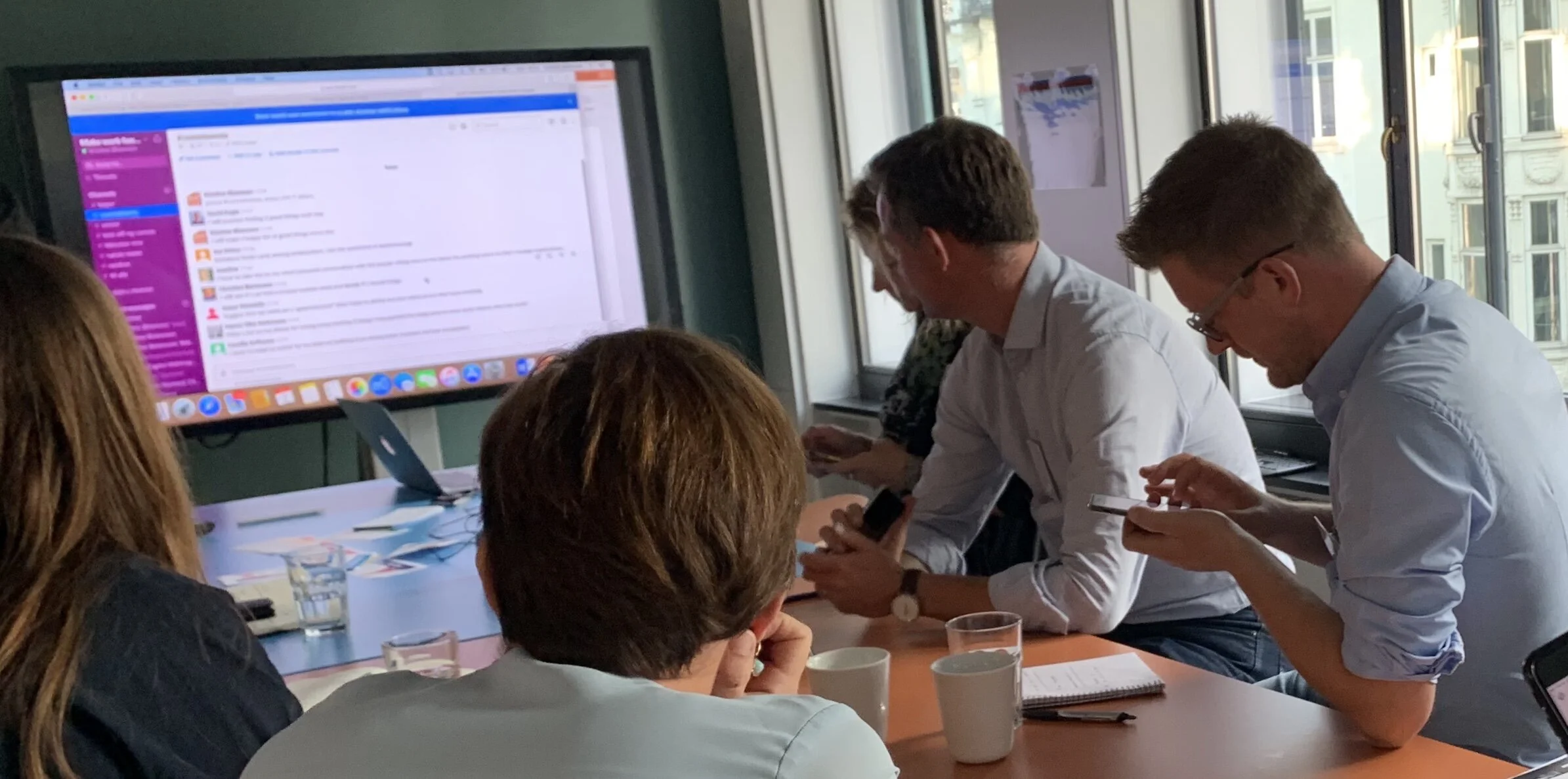 Participants gather at a table and view a computer screen.