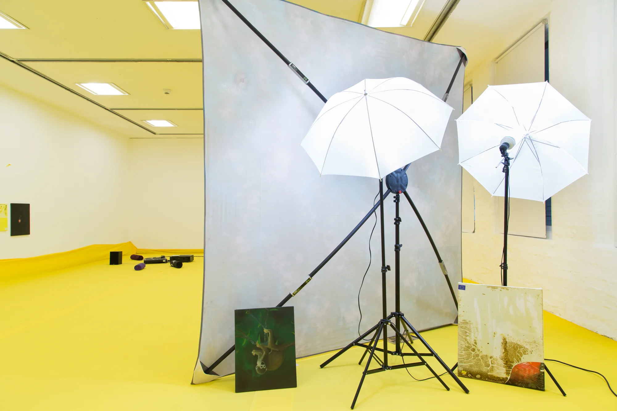 Installation view of 'Do U Feel Like We Do? at Intermedia Gallery, CCA Glasgow 2014. (Cotton, X-frame, photographic background, studio lights, towels, oil paint, turntable, amplifier, speakers, silicon gel bracelets, screws, inkjet prints, coins, plaster and video paint.) Photo: Tom Nolan