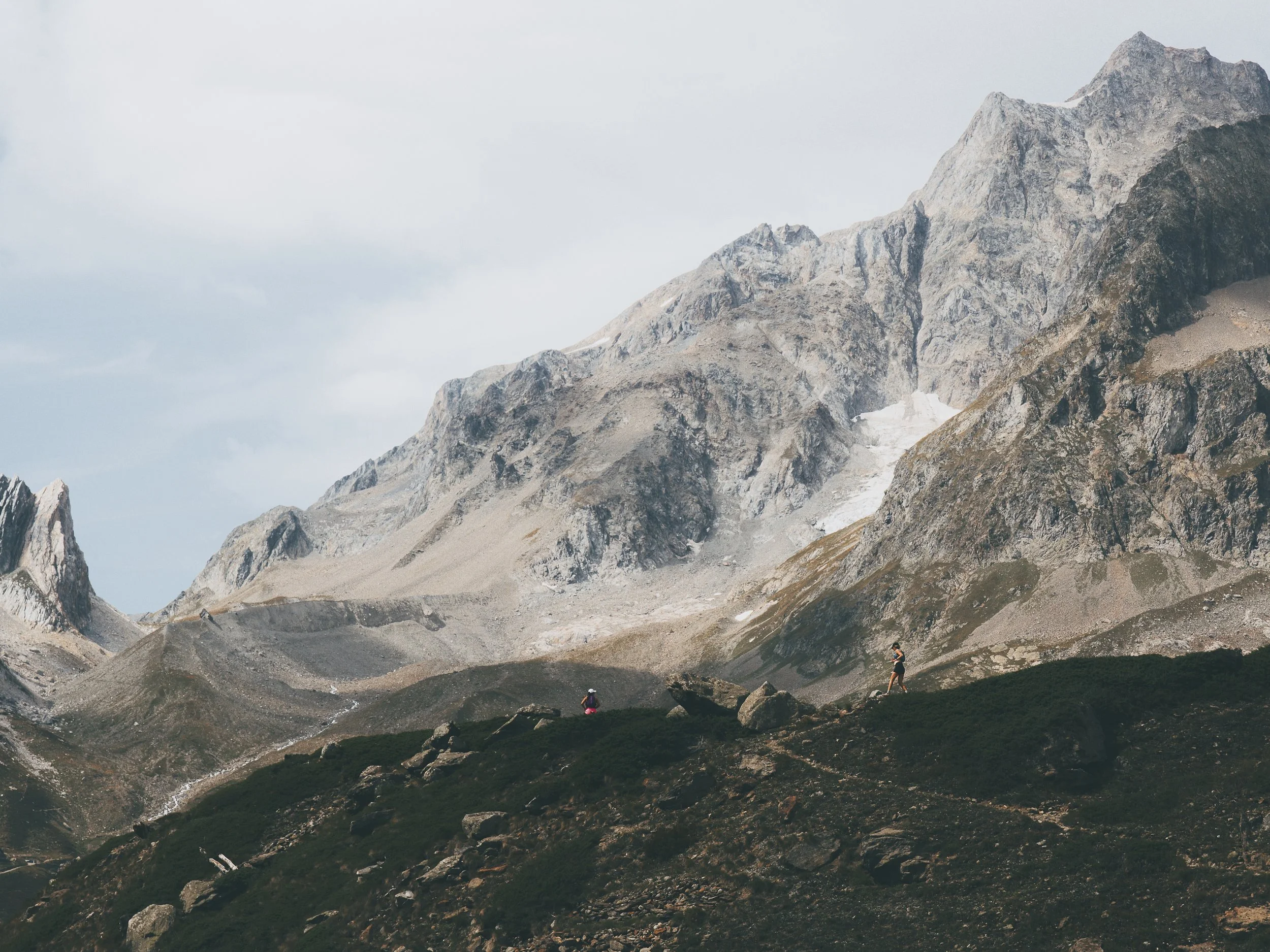 trail runners on a runcation travel trip make their way from italy to switzerland on the tour du mont blanc