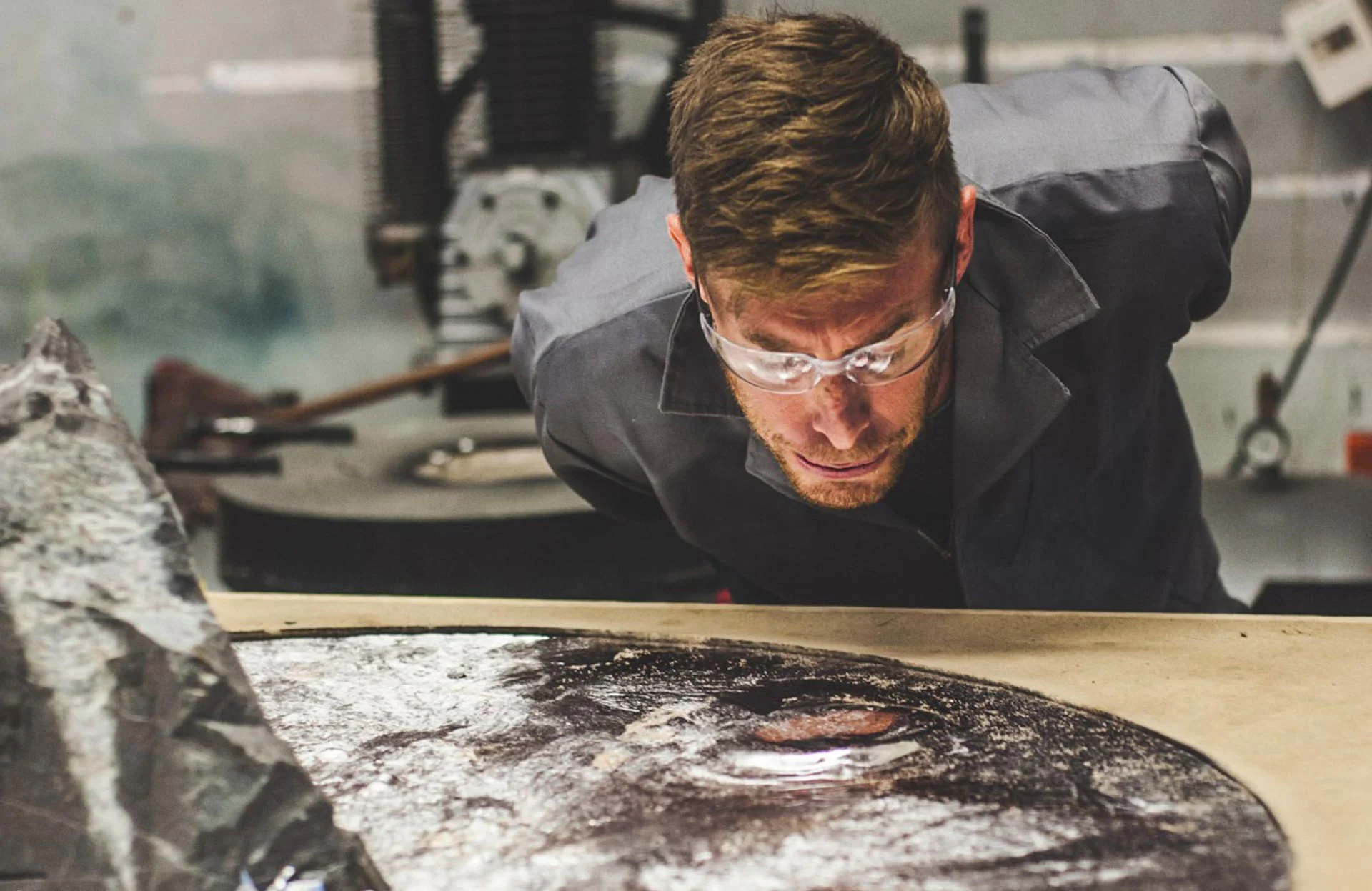 Jesse taking a closer look at one of his creations — Lunar Table. (Photo by Devin Paisley)