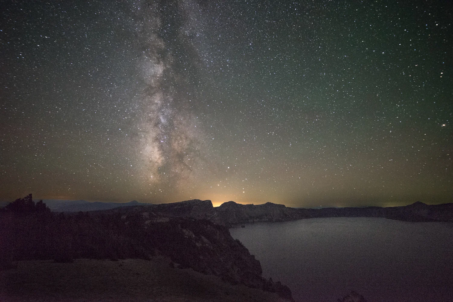 The Milky Way rises over Crater Lake. The Galactic Center is visible in this photo.