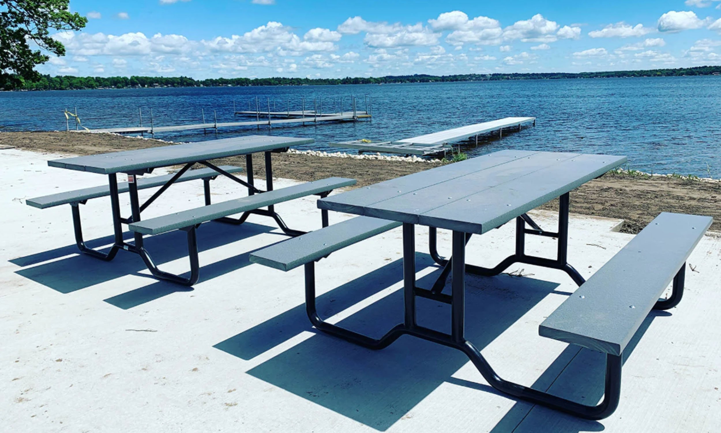 Commercial picnic tables with powder-coated steel frames installed at waterfront park — Made in Michigan