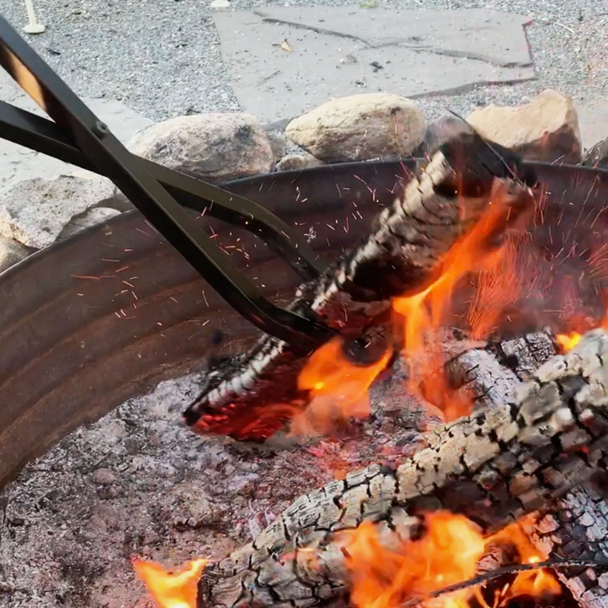 40-inch Log Claw gripping burning log in steel fire pit