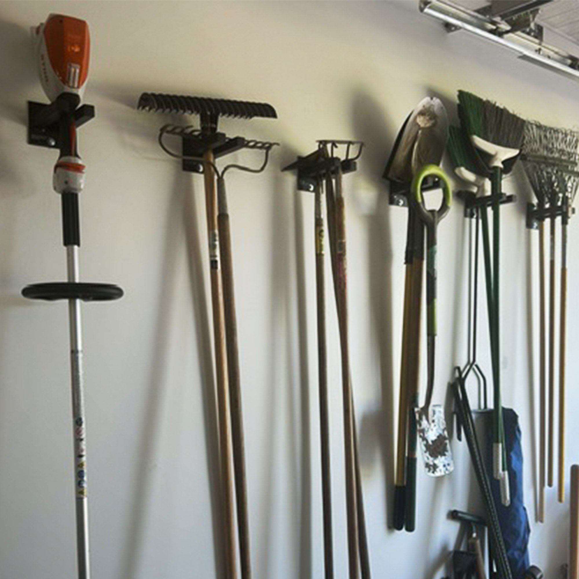 Customer install featuring 6-inch and larger Double Prong Tool Racks holding yard tools, snow shovels, and rakes in a Michigan garage
