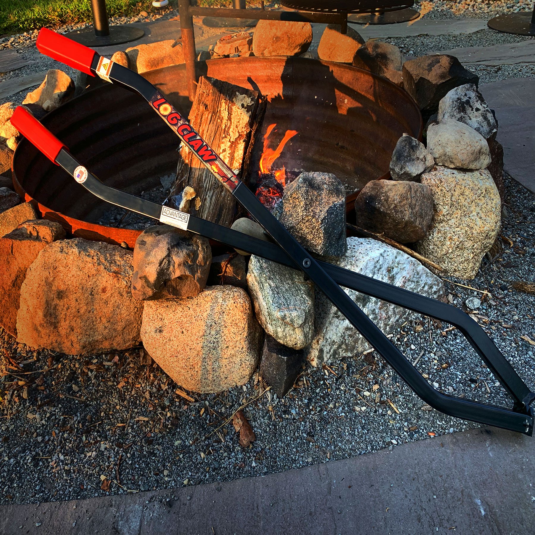 40" Firewood Log Claw resting on fire pit rocks, Satin Black finish.