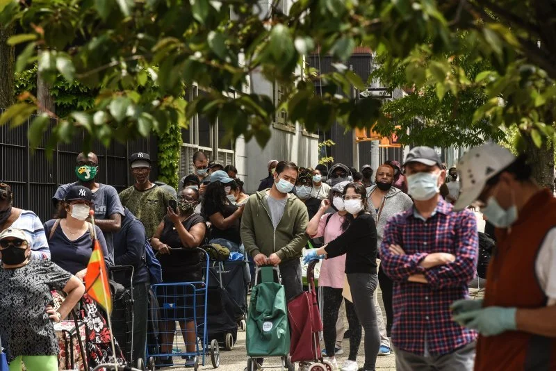 People wait on a long line to receive a food bank donation at the Barclays Center on May 15 in Brooklyn. The sports arena saw lines wrap around the block as New Yorkers struggle with unemployment and other financial stresses brought on by the COVID-…