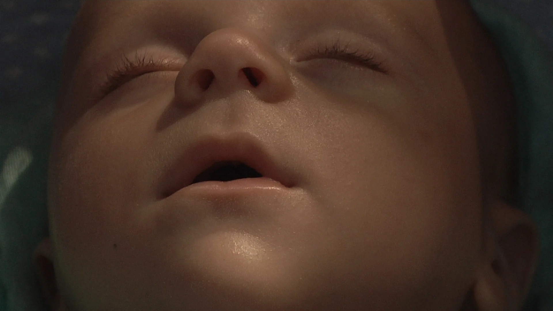 Other people's babies , 2014. Video projection, 04:30 minutes, loop. Five close-ups of five babies sleeping in their strollers. The film was shot on the streets and in public parks of Tel- Aviv, while approaching random people and asking permission to film their baby sleeping.