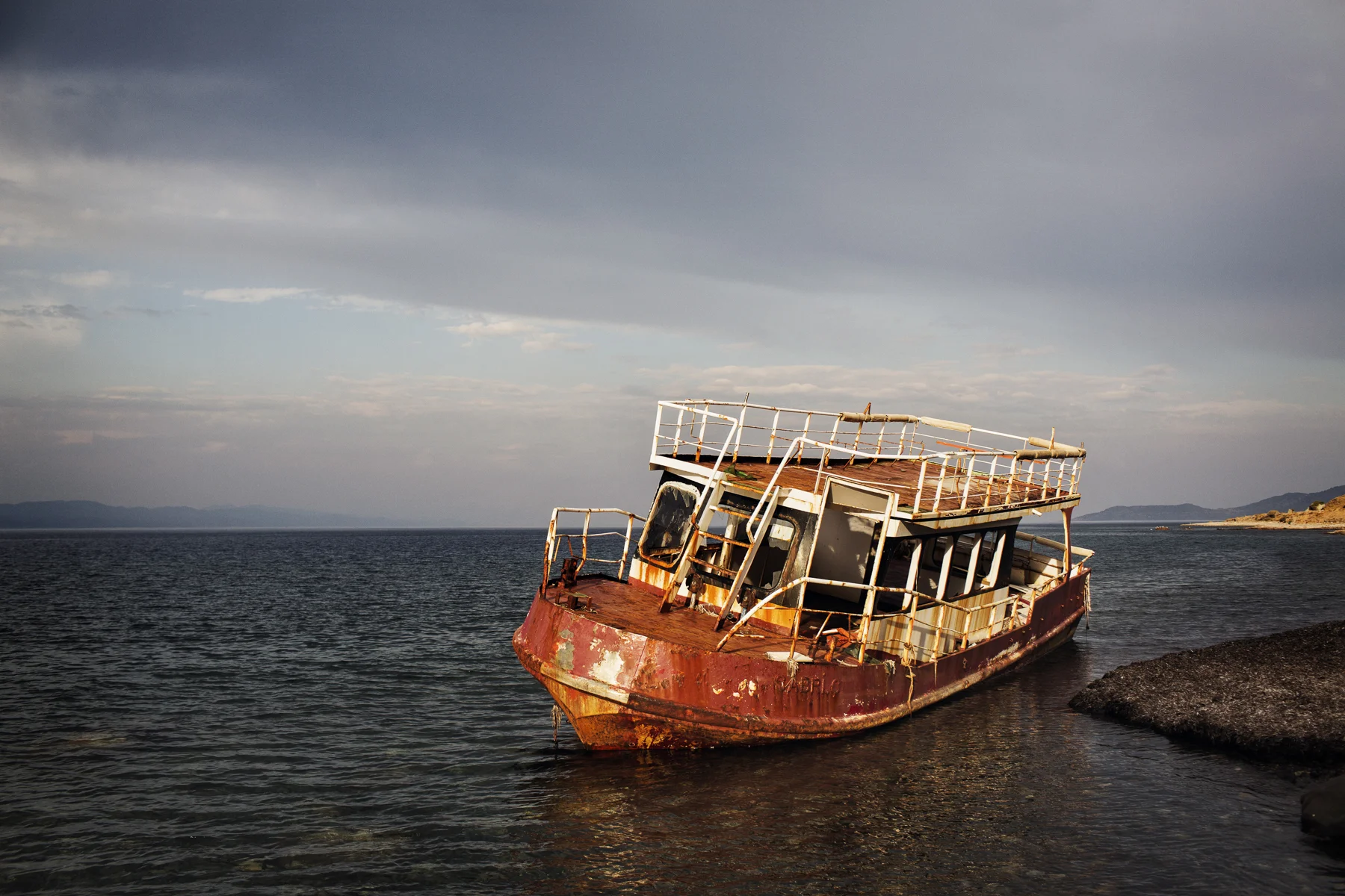 A stranded refugee ship seen near Eftalou on the island of Lesvos, Greece. In 2015, thousands of refugees arrived daily on the shores of Lesvos sometimes smuggled in ships like these, but mostly in cheap rubber dinghies.