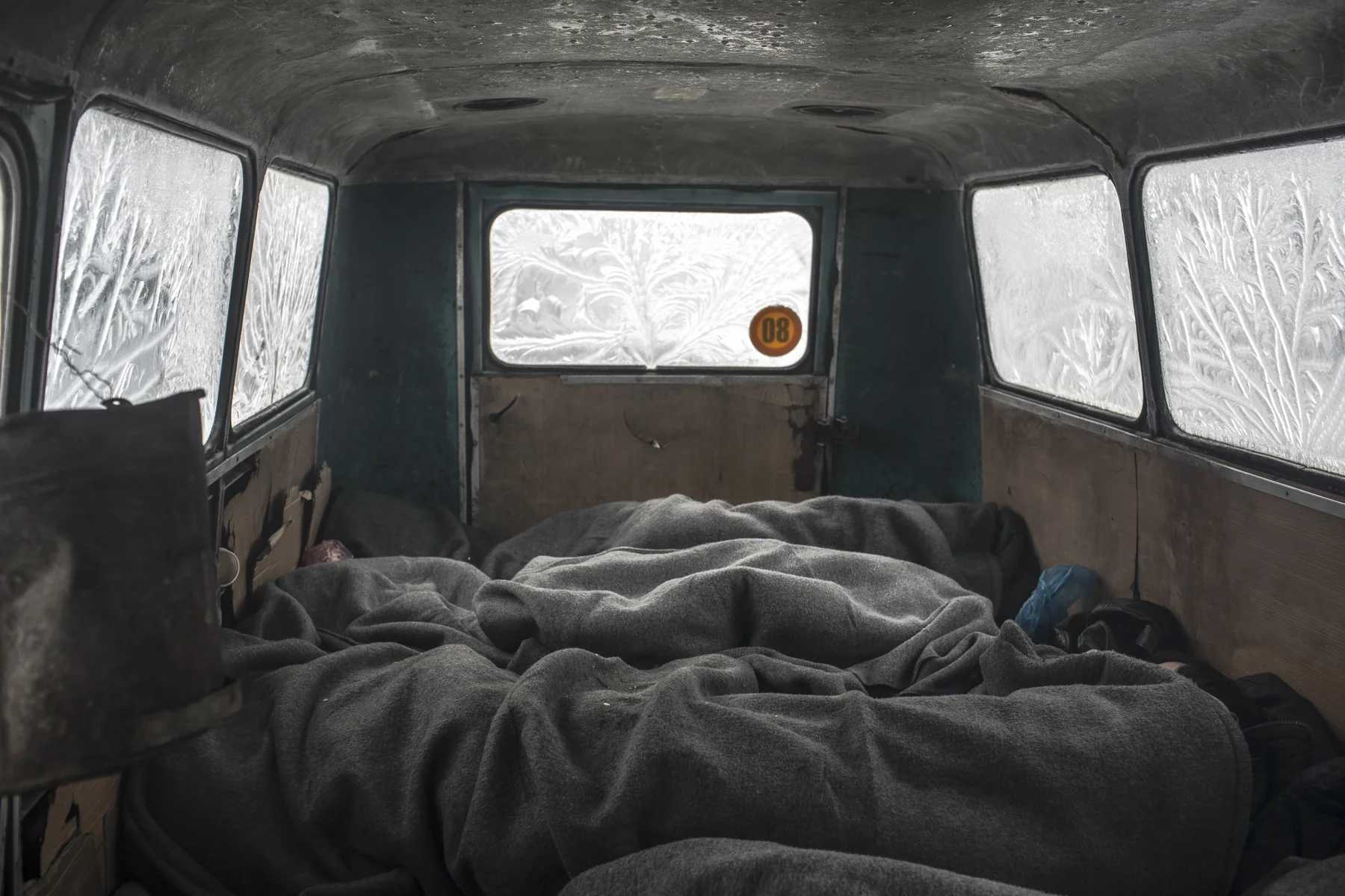 Men sleep in an abandoned bus behind the central train Station in Begrade, where close to a thousand refugees and migrants, mostly from Pakistan and Afghanistan, are sleeping rough.