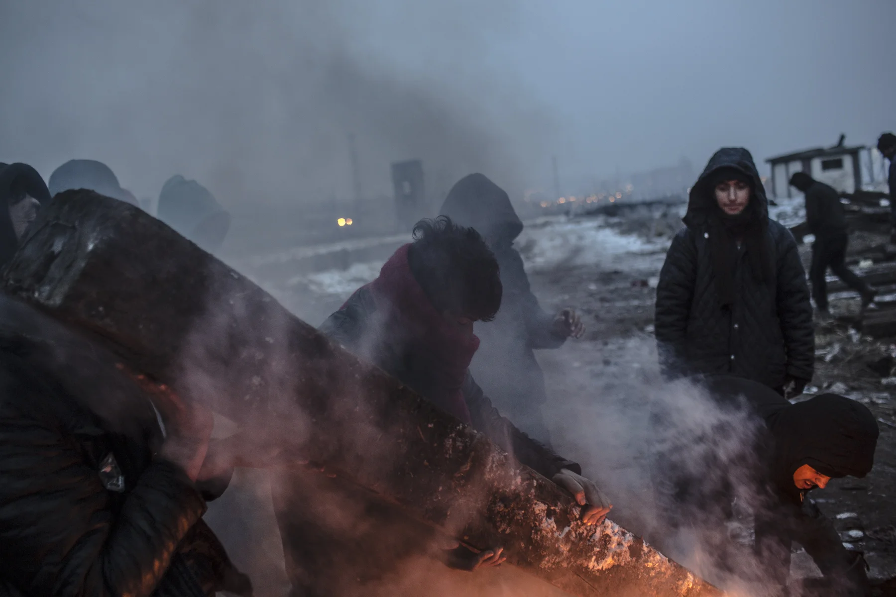 Men carry a railway sleeper to a fire place behind the train station in Belgrade.
