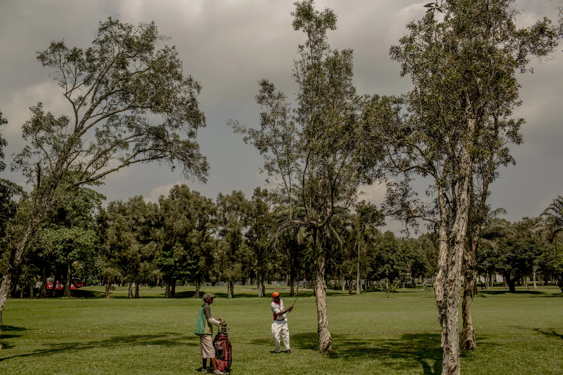 A man plays golf in the center of Kinshasa. 