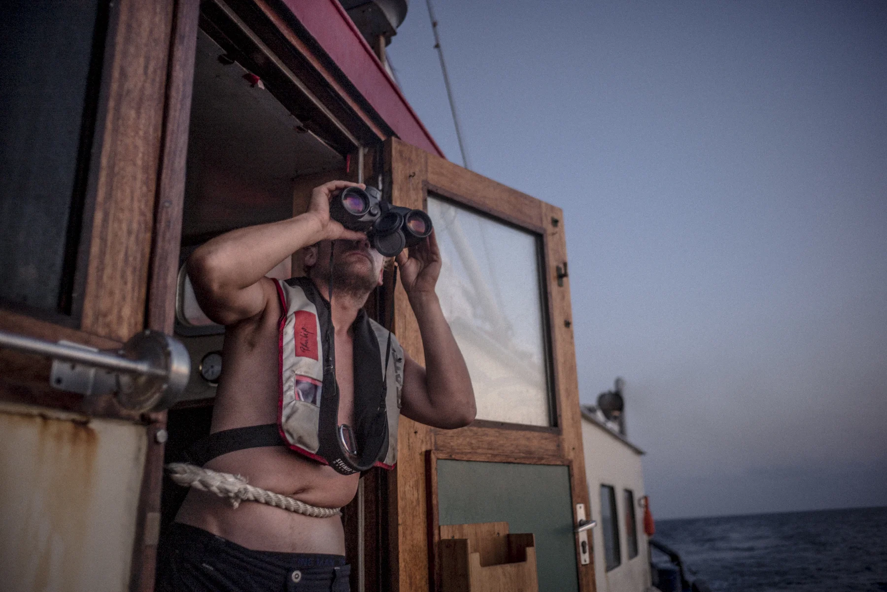 Philipp Hahn, a crewmember of the Sea-Watch, observes the sea in front of the vessel as it sails towards the Libyan coast from Lampedusa.