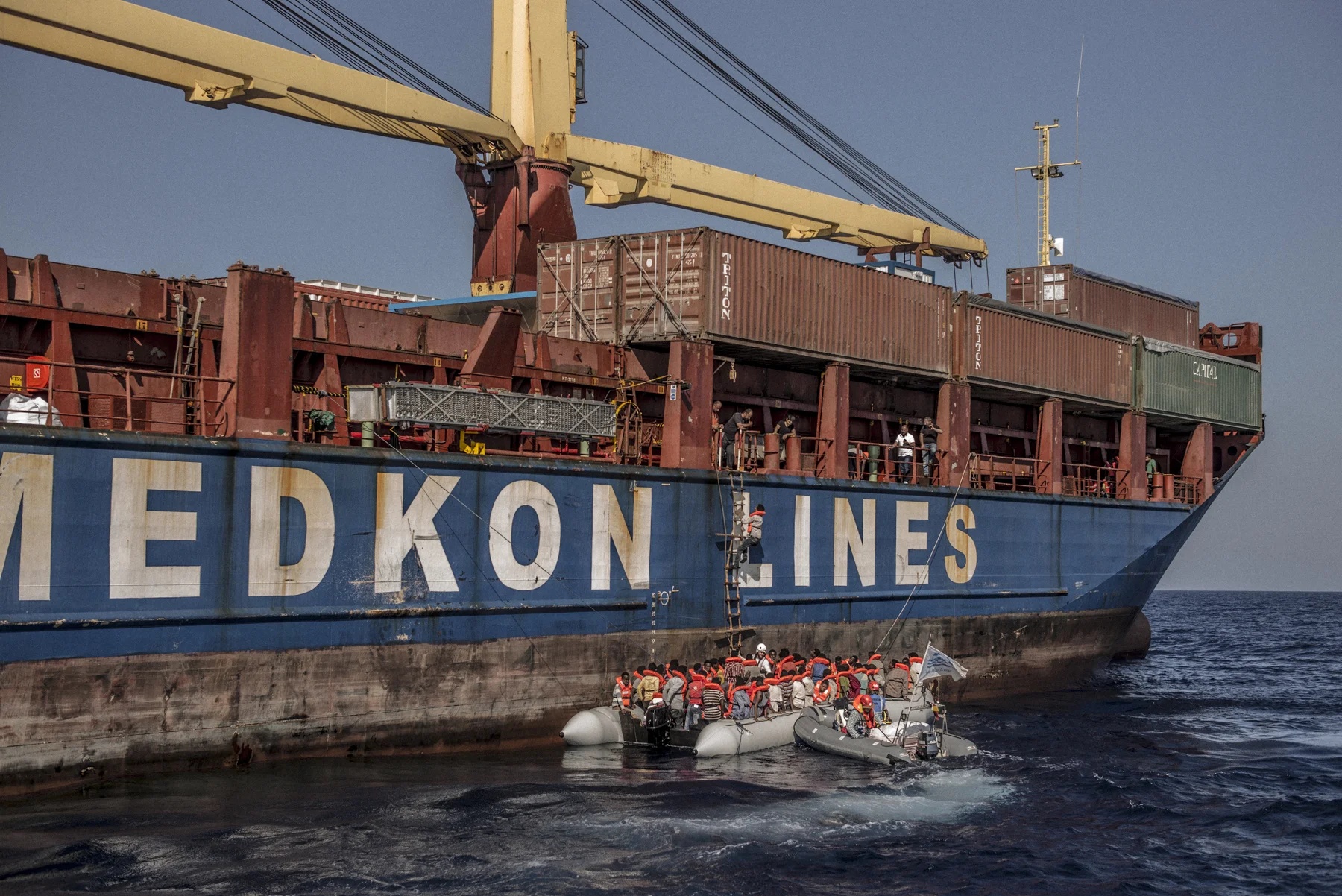 The crew of the Sea-Watch assists migrants and refugees boarding the freight ship Shaya.