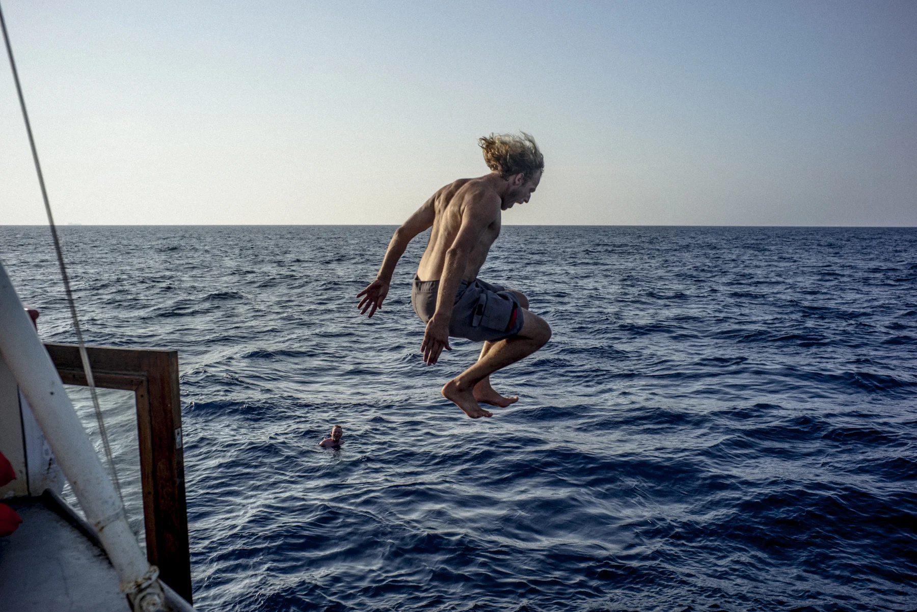 During a break, Mike Schoepping, the chief mechanic on the Sea-Watch, jumps from the roof of the vessel.