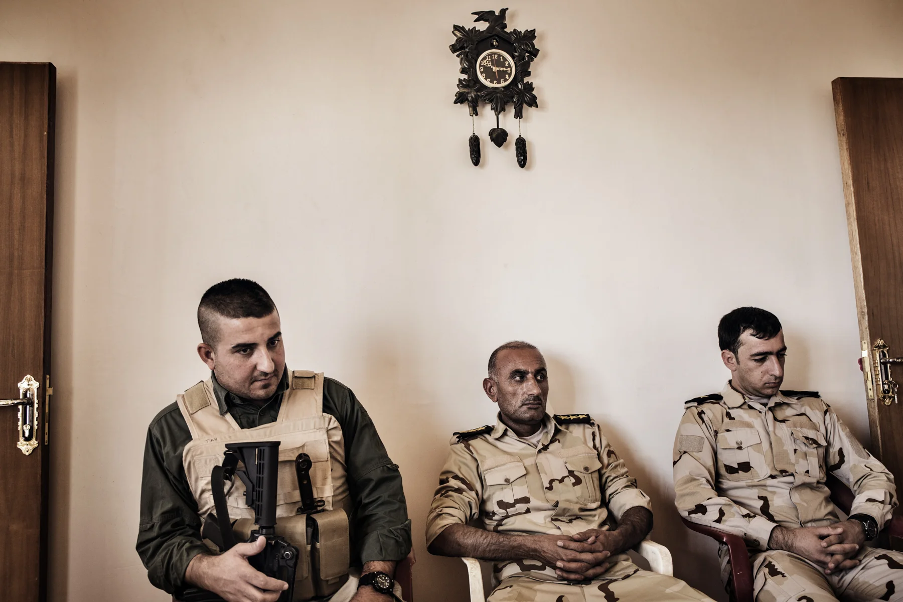 A Kurdish employee of a German private military company sits with Iraqi soldiers in a Peshmerga outpost outside of Makhmour, Iraq.
