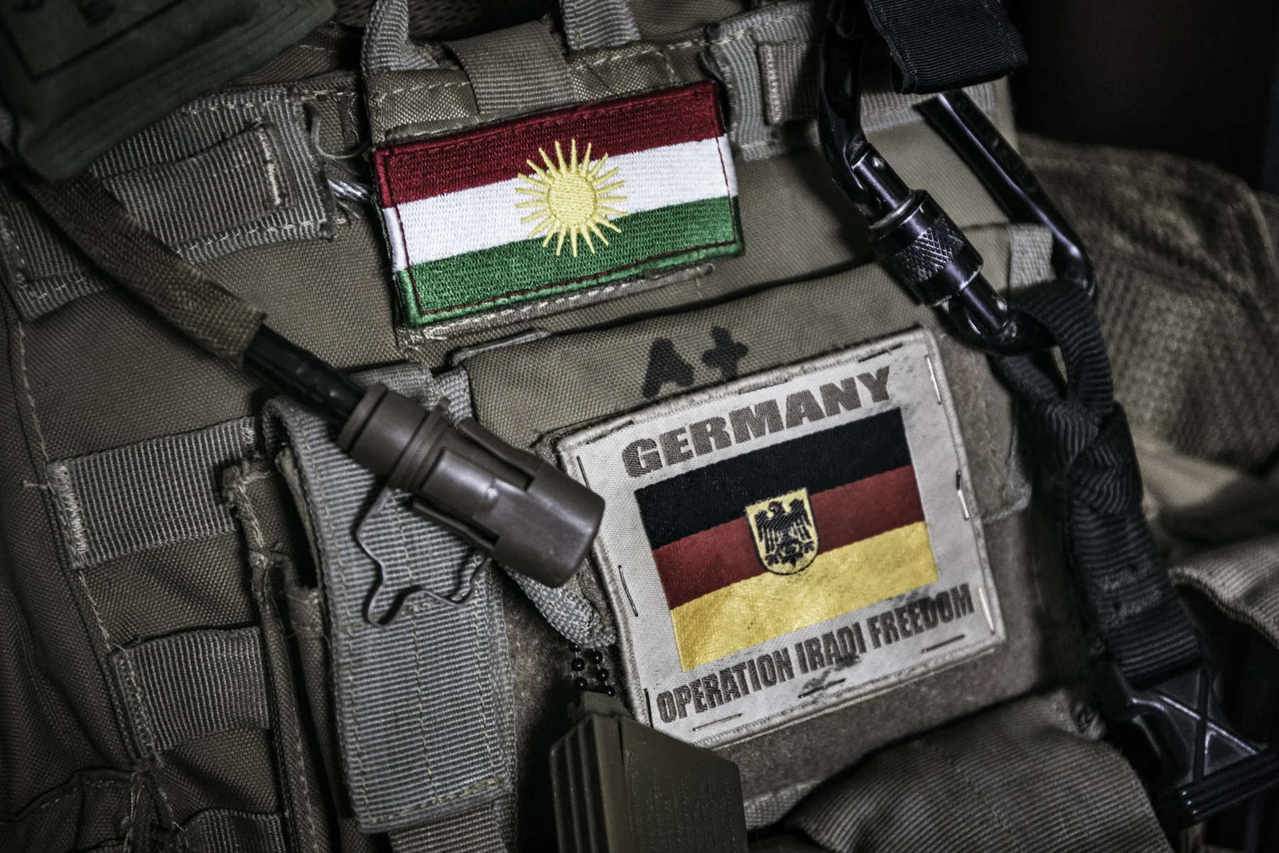 German and Kurdish flags seen on a flak jacket of a German private security company. 
