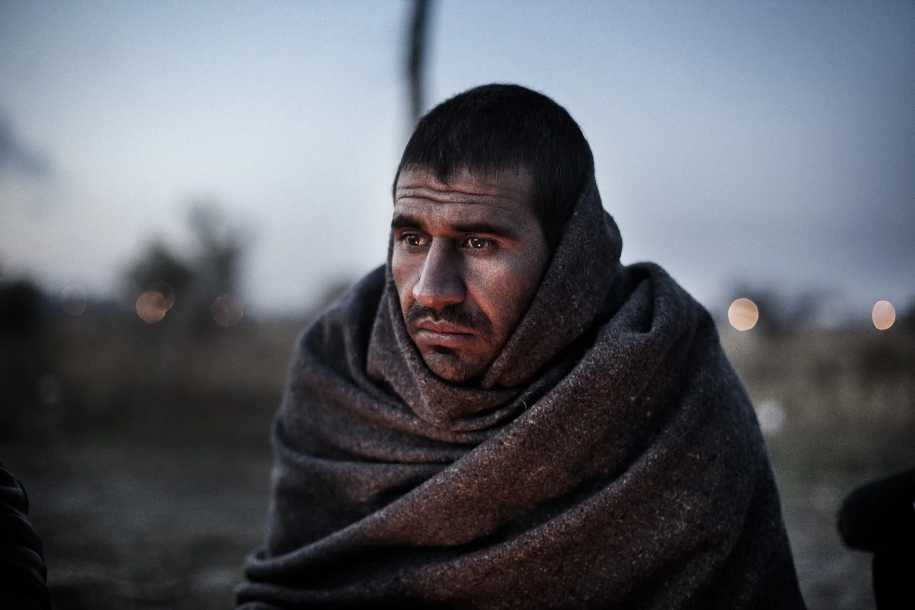 Yousuf Zai Firuz, an Afghan refugee, sits by a fire outside Subotica, Serbia. 