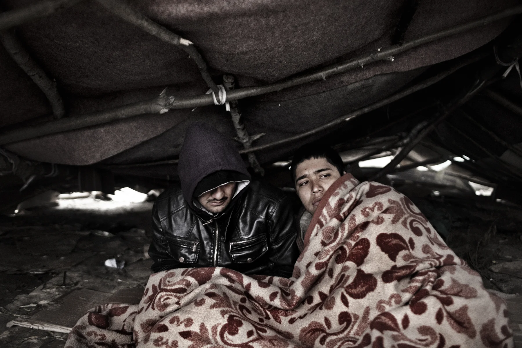 Zahir (left) and Kabir, Afghan refugees, wake up after a night in a makeshift tent, Subotica, Serbia. They are waiting for smugglers to take them to nearby Hungary. 