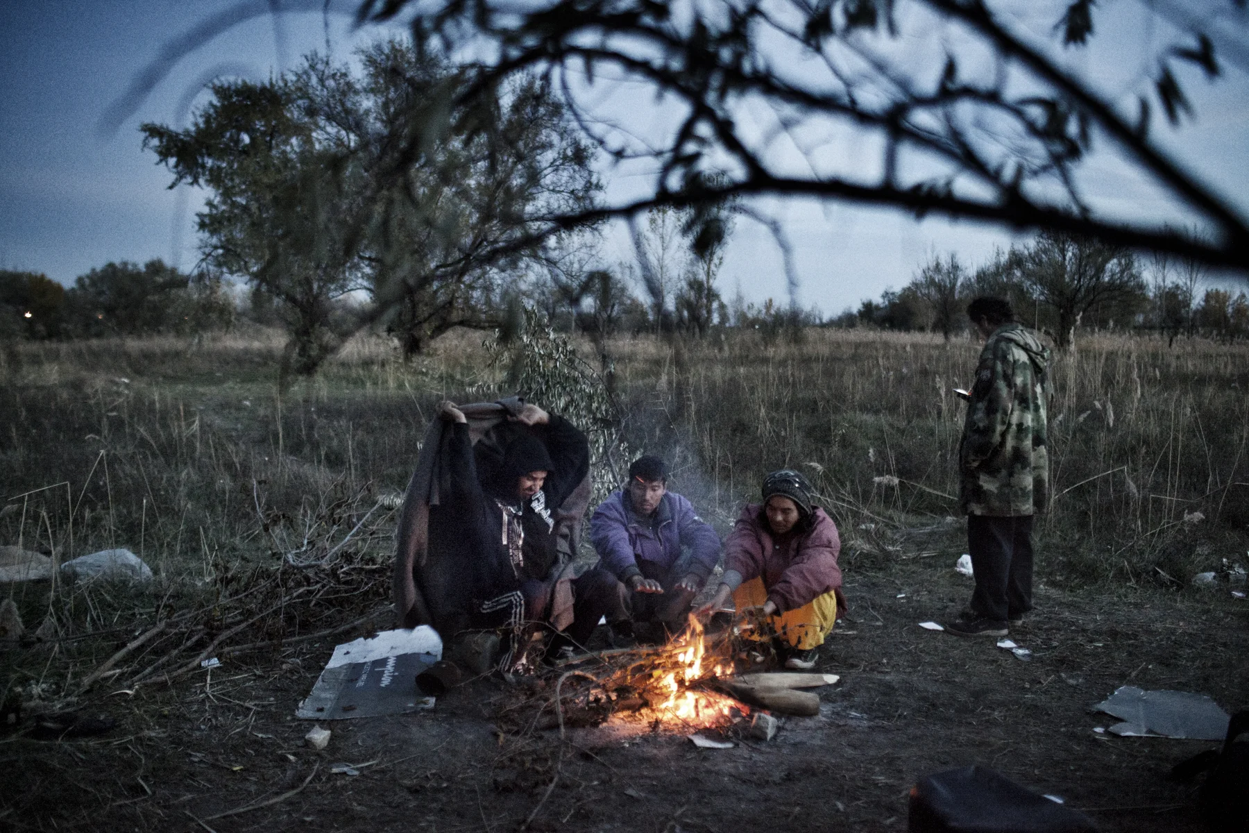 Refugees from Afghanistan sit around a fire in fields outside Subotica, Serbia near the border to Hungary. 