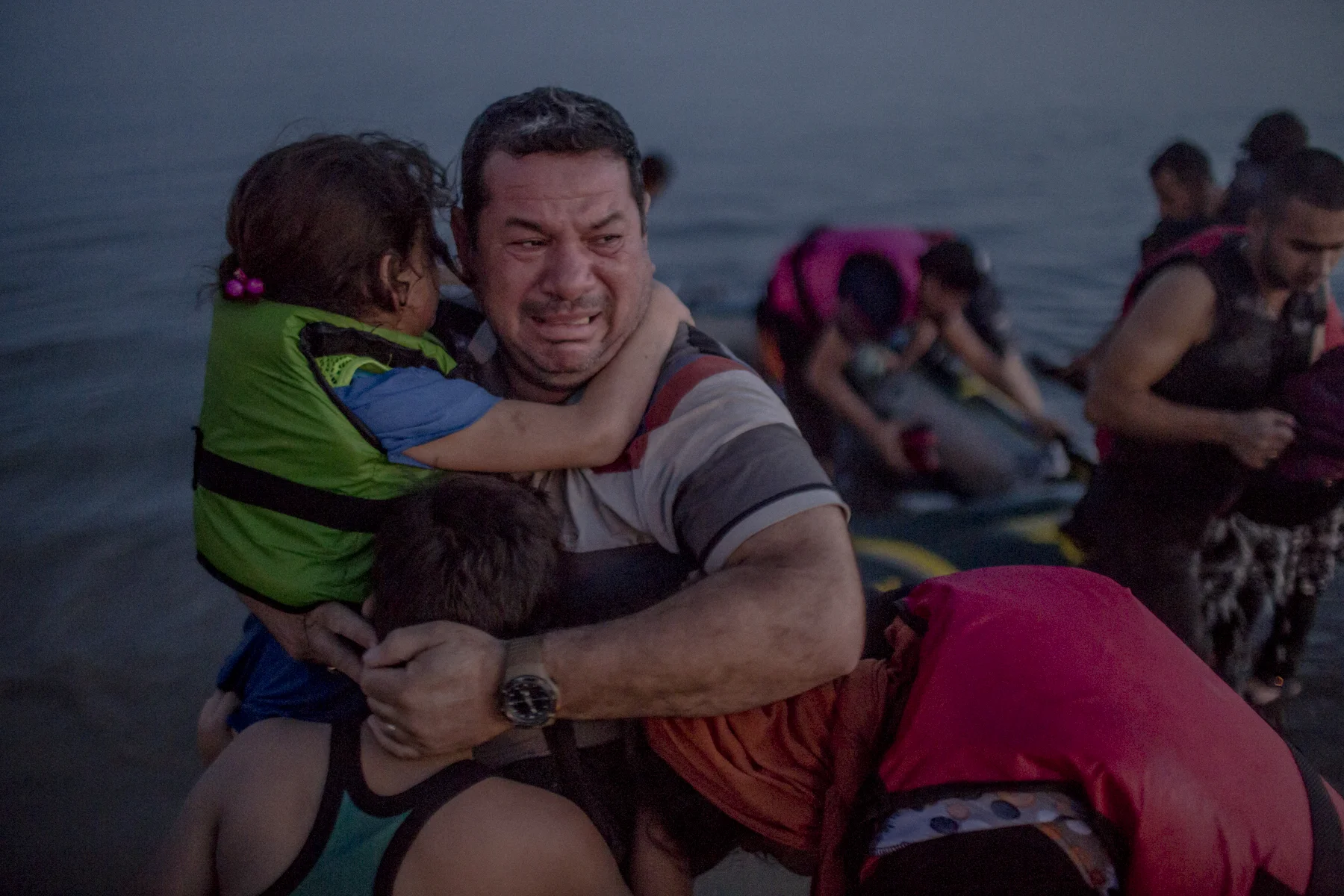 Laith Majid al Amiri cries as he holds his youngest children as they arrived on the Greek island of Kos. 