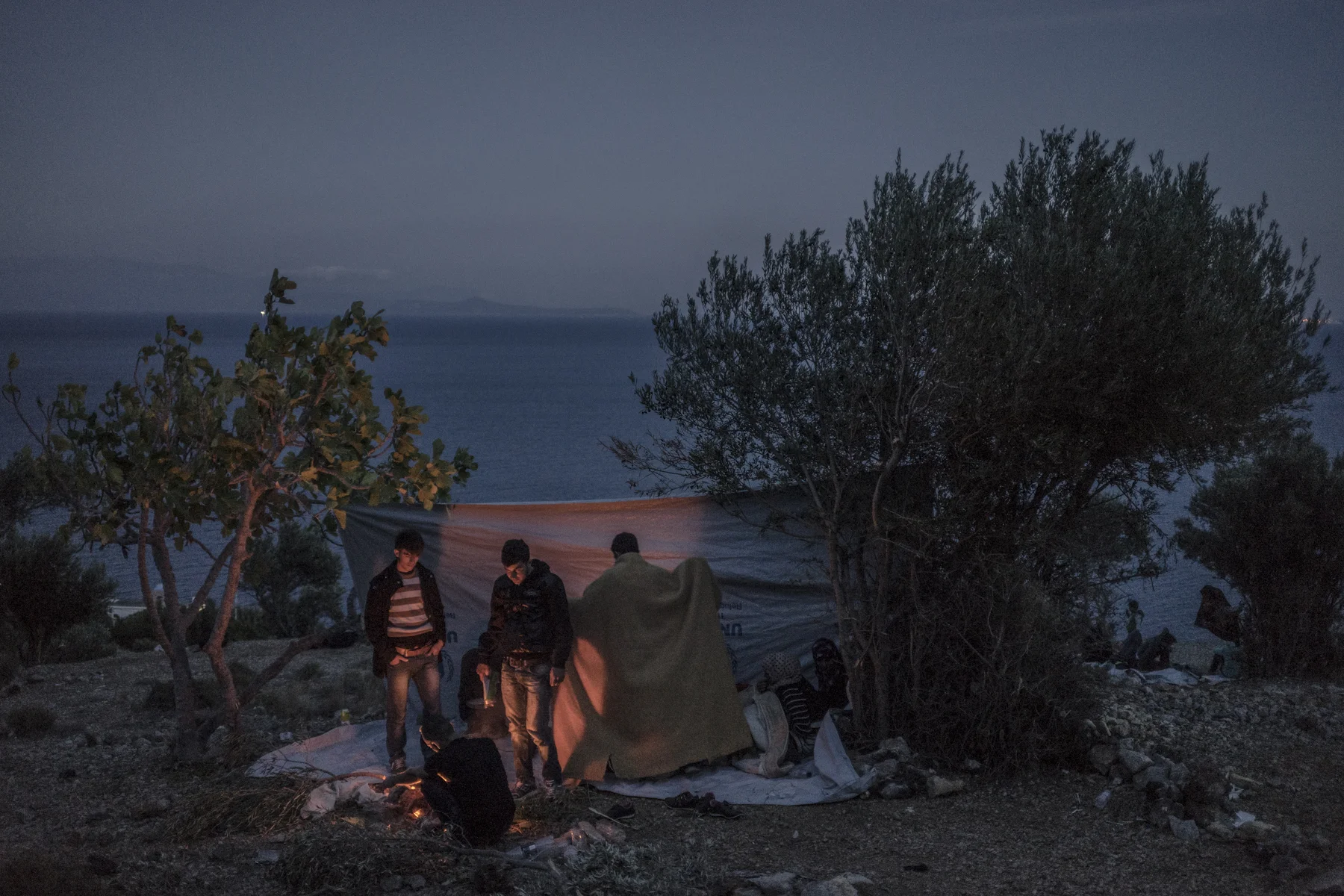 Syrian refugees huddle around a fire on the Greek island of Chios.