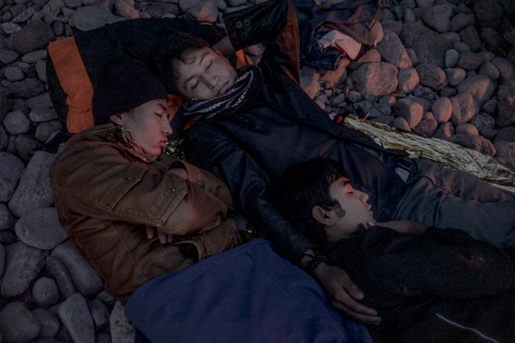 Afghan boys sleep on a beach on Lesbos.