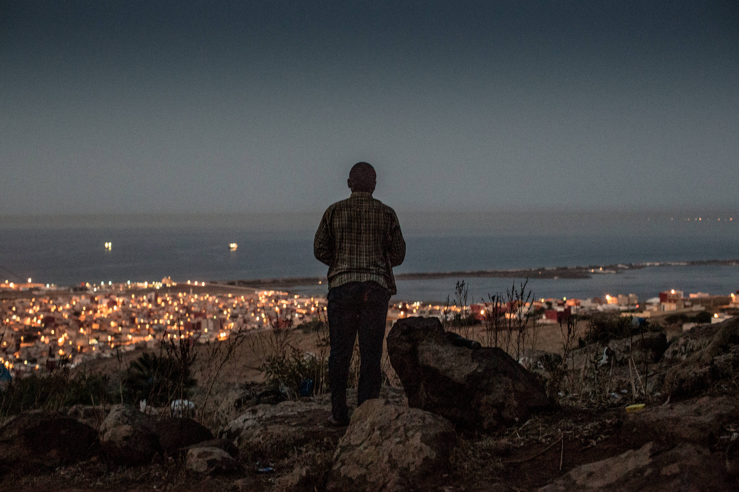A Malian man prays overlooking Melilla.