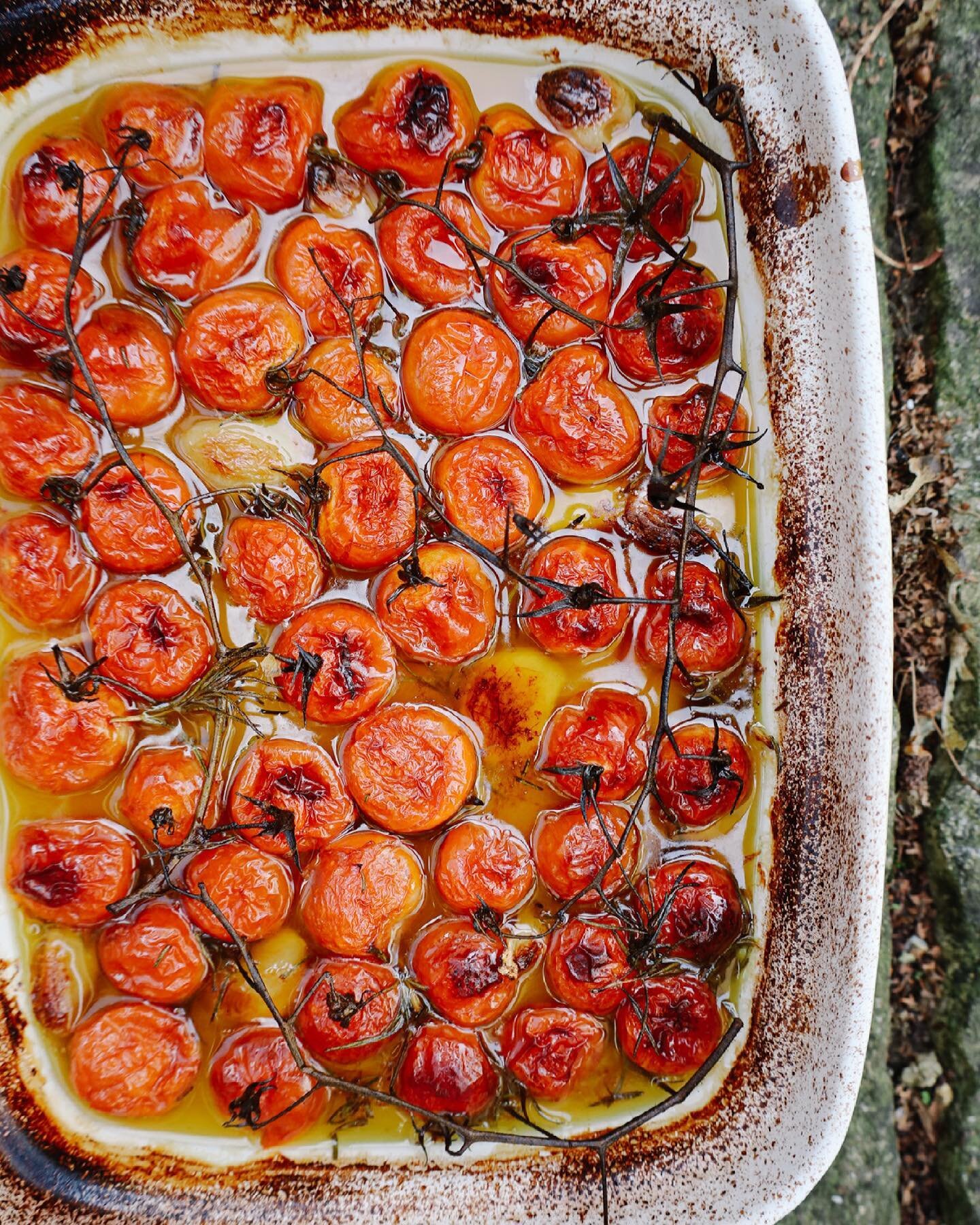 Tomatoes on the vine, the peeled cloves from a whole bulb of garlic and a few sprigs of rosemary. Nestled in a shallow pool of olive oil before being gently cooked for two hours. Confit and delicious.