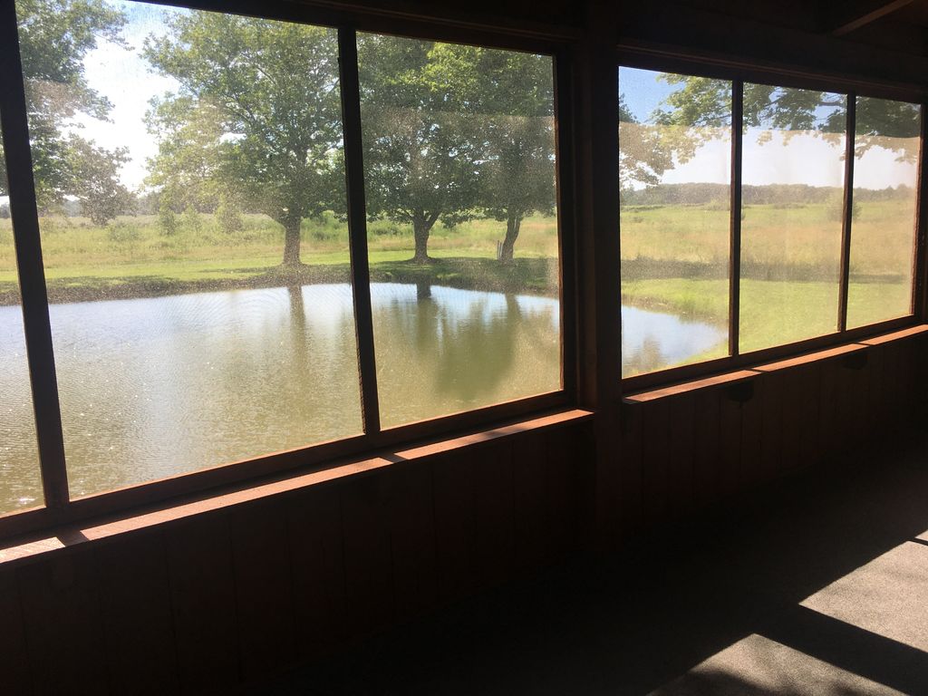 Screened in porch has views of pond next to cabin