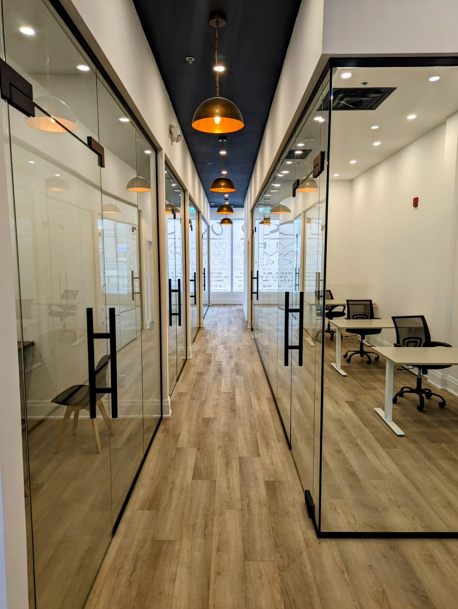 The professional hallway of OMNI LAW GROUP in Brampton, showing modern glass-walled offices and a welcoming environment.
