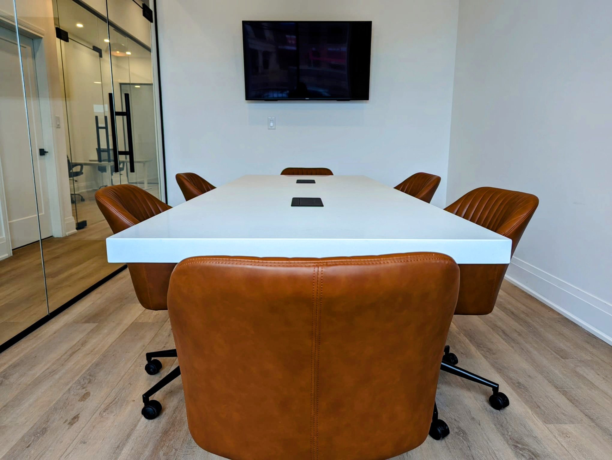 A modern, professional meeting room at OMNI LAW GROUP in Brampton, featuring a white conference table and leather chairs for legal consultations.