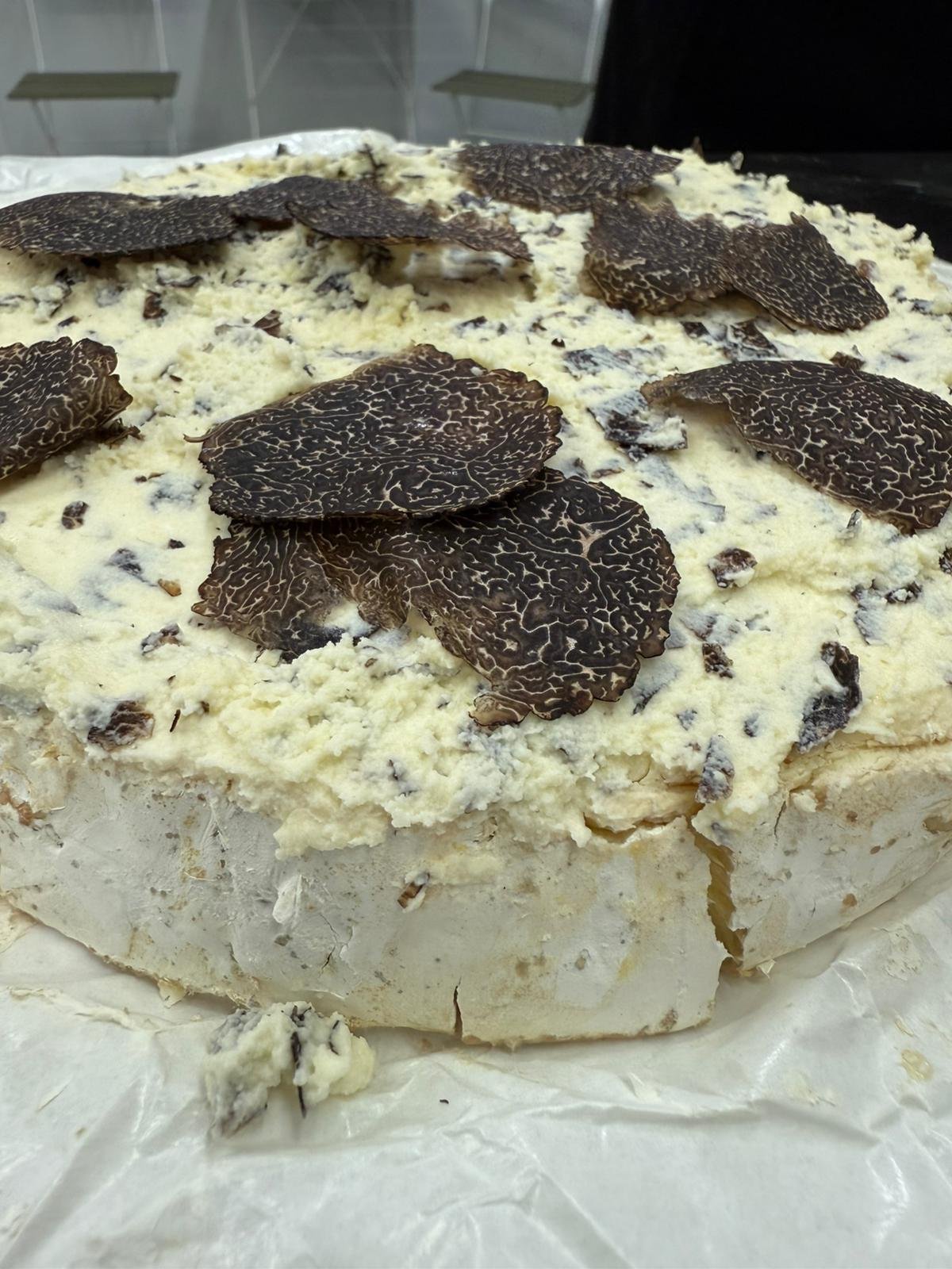 Creamy Brie Fermier cheese topped with freshly shaved Flinders black truffle, showcasing the rich contrast between pale cheese and dark truffle
