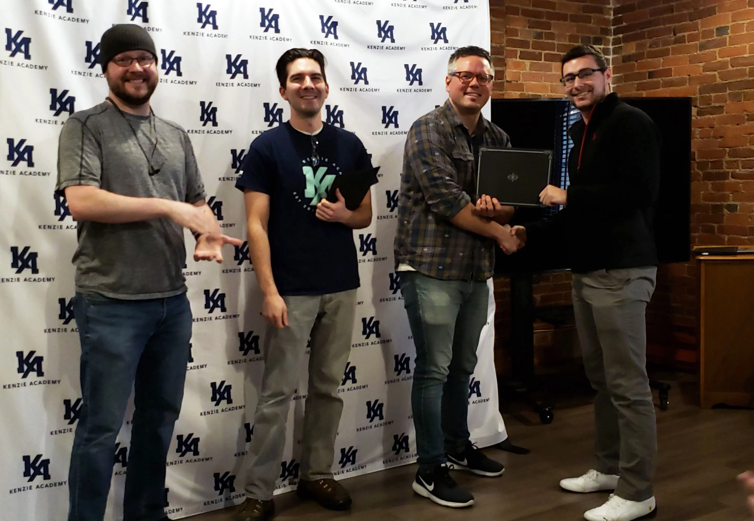 Software Engineering student, Austin Levine, accepting his Front-End Web Development Certificate from Matt, Taylor & DMG