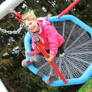 Basket swings are undiably popular pieces of playground equipment, I think this child's face says it all.