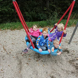 A group of children bundled together on one of our basket swings.